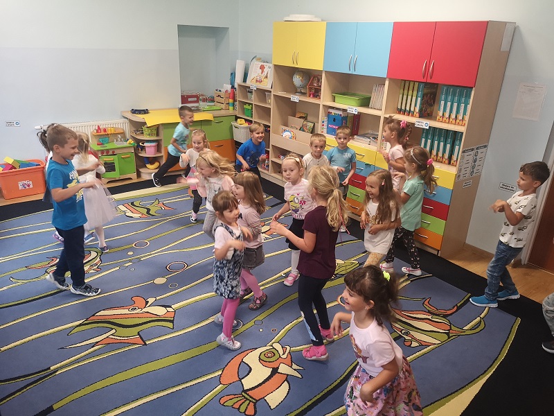 Na zdjęciu widać wesołe dzieci z grupy Jeżyków podczas zabawy przy muzyce.