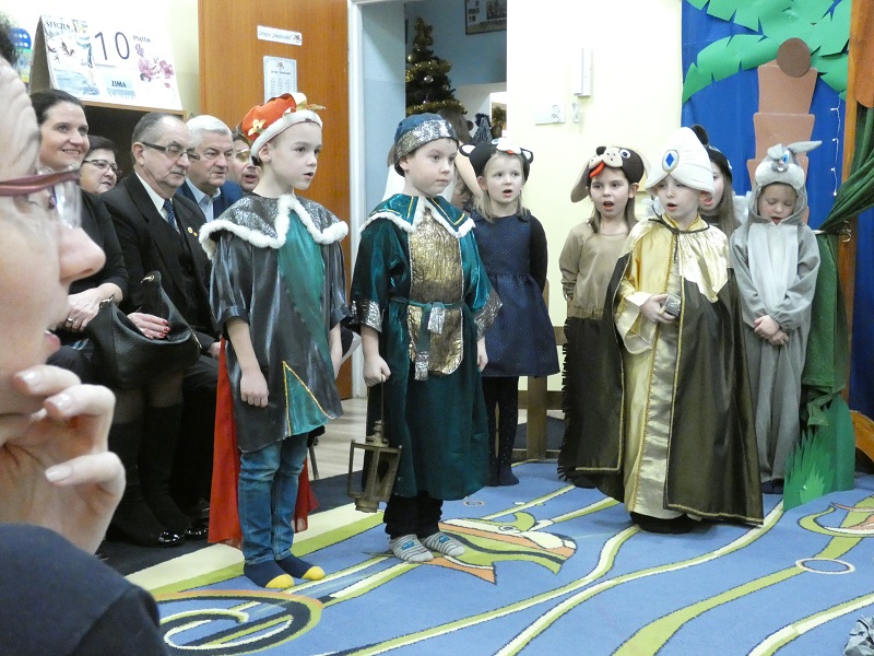 Dzieci przebrane za Trzech Króli z tyłu goście i zwierzęta.