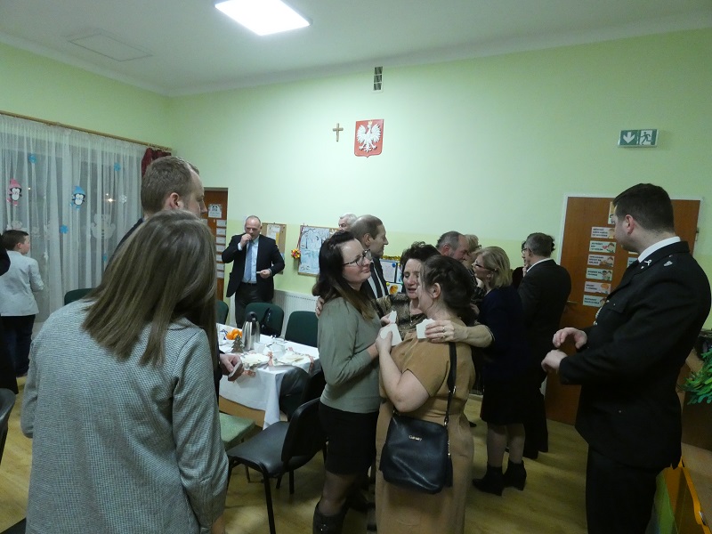 Sala pełna gości na wprost wysoko na ścianie widnieje Krzyż obok Godło.