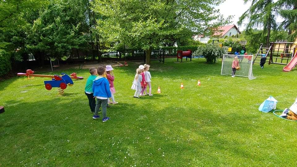 Dzieci podczas zabaw sportowych na przedszkolnym placu zabaw.