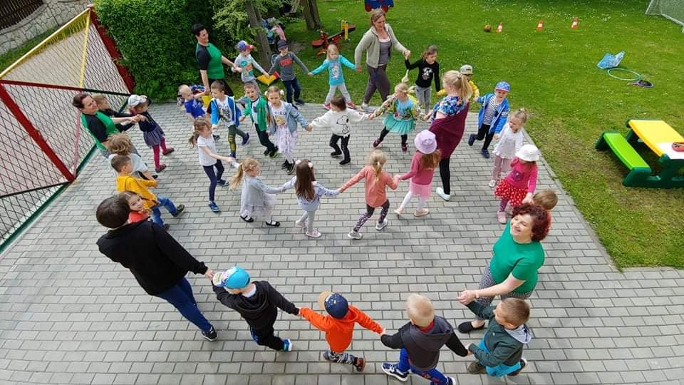 Dzieci oraz kadra przedszkola tańczą w dwóch kołach do piosenek.