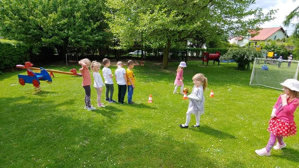 Dzieci podczas zabaw sportowych na przedszkolnym placu zabaw.