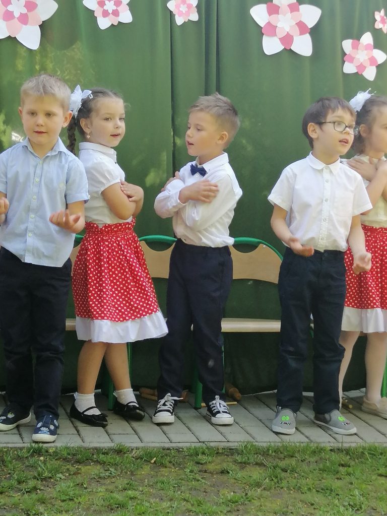 Piątka dzieci tańczy i śpiewa piosenkę o mamie.