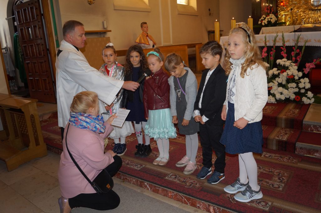 Dzieci prezentujące modlitwę wiernych podczas mszy świętej z okazji Dnia Patrona.