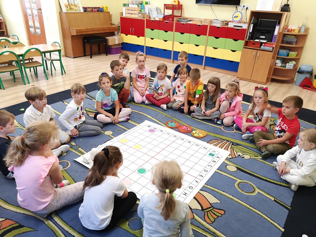 Dzieci podczas zajęć edukacyjnych z matą do kodowania.