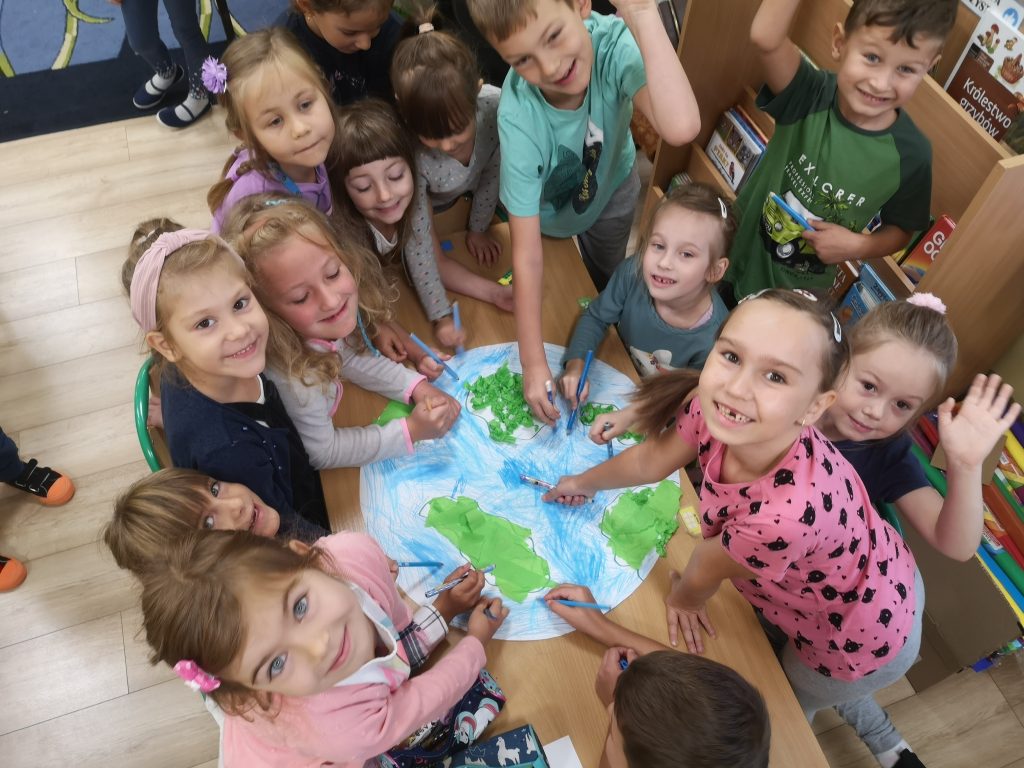 Dzieci wykonują wspólnie prace plastyczną - Planetę Ziemię.