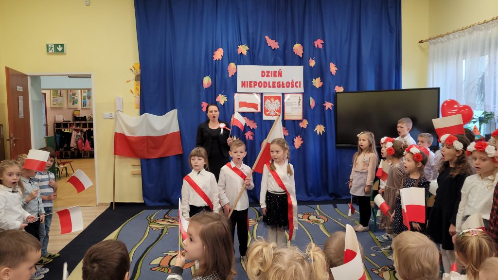 Przedszkolaki śpiewają hymn Polski podczas apelu z okazji Święta Niepodległości.