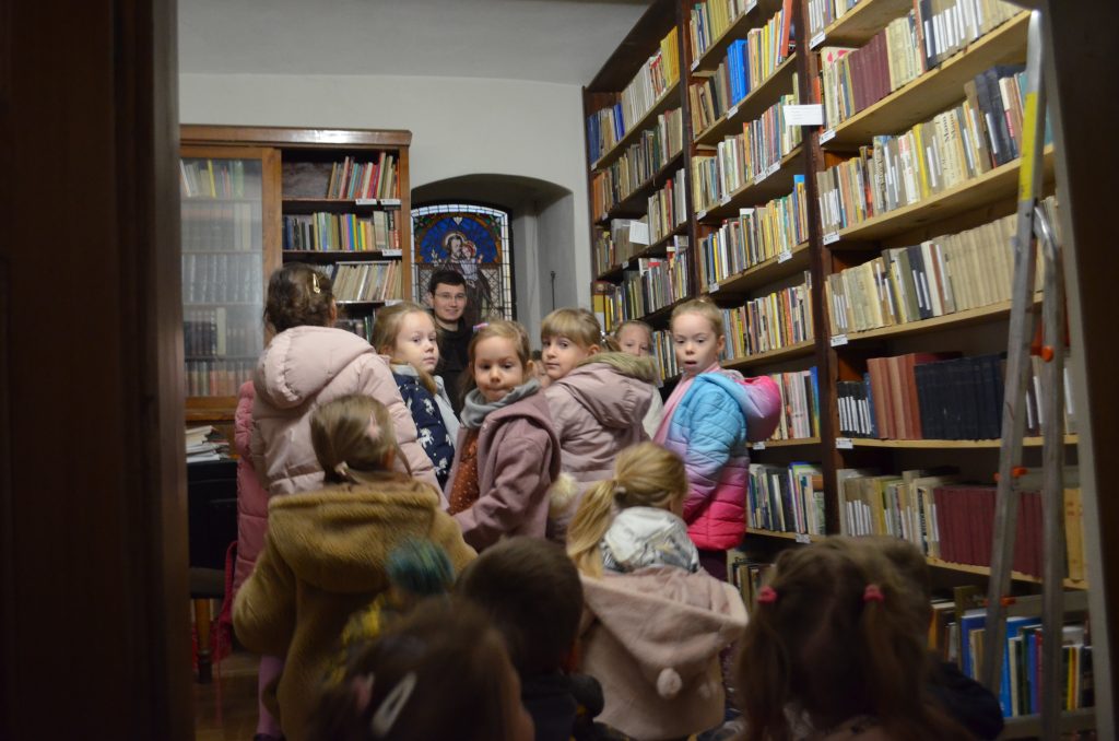 Dzieci zwiedzają bibliotekę przyklasztorną oraz podziwiają jej księgozbiory (starodruki), które pochodzą z XVII w.