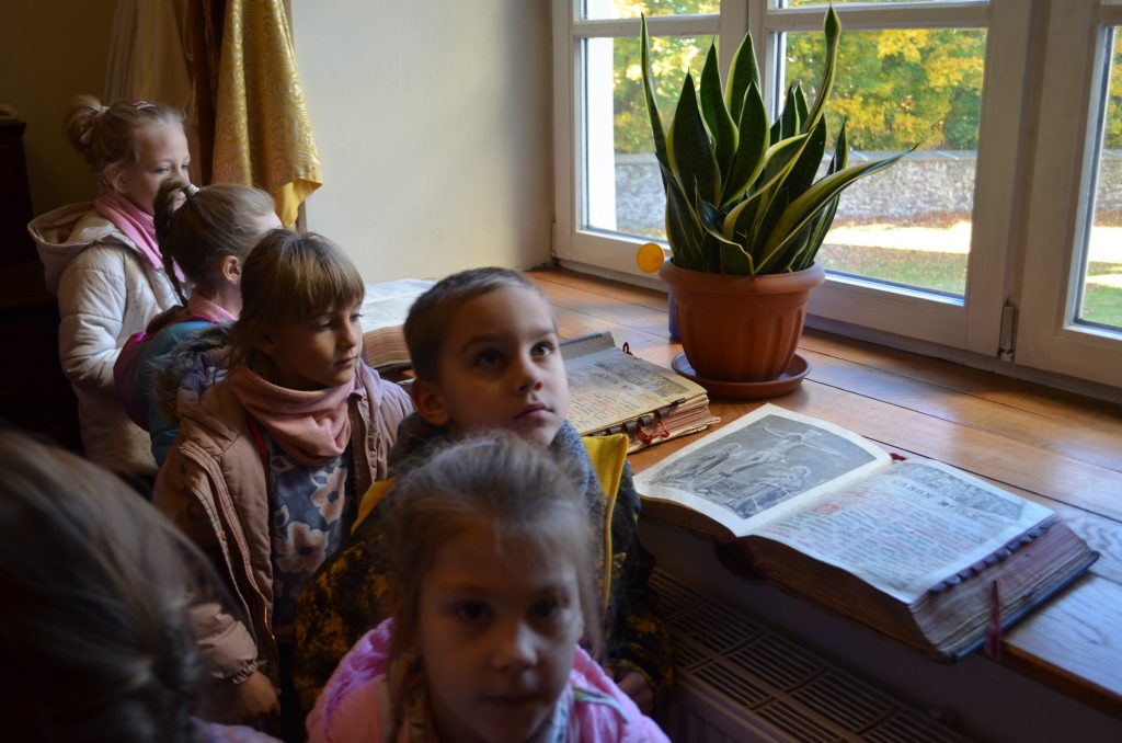 Dzieci podziwiają księgozbiory (starodruki) z XVII w.