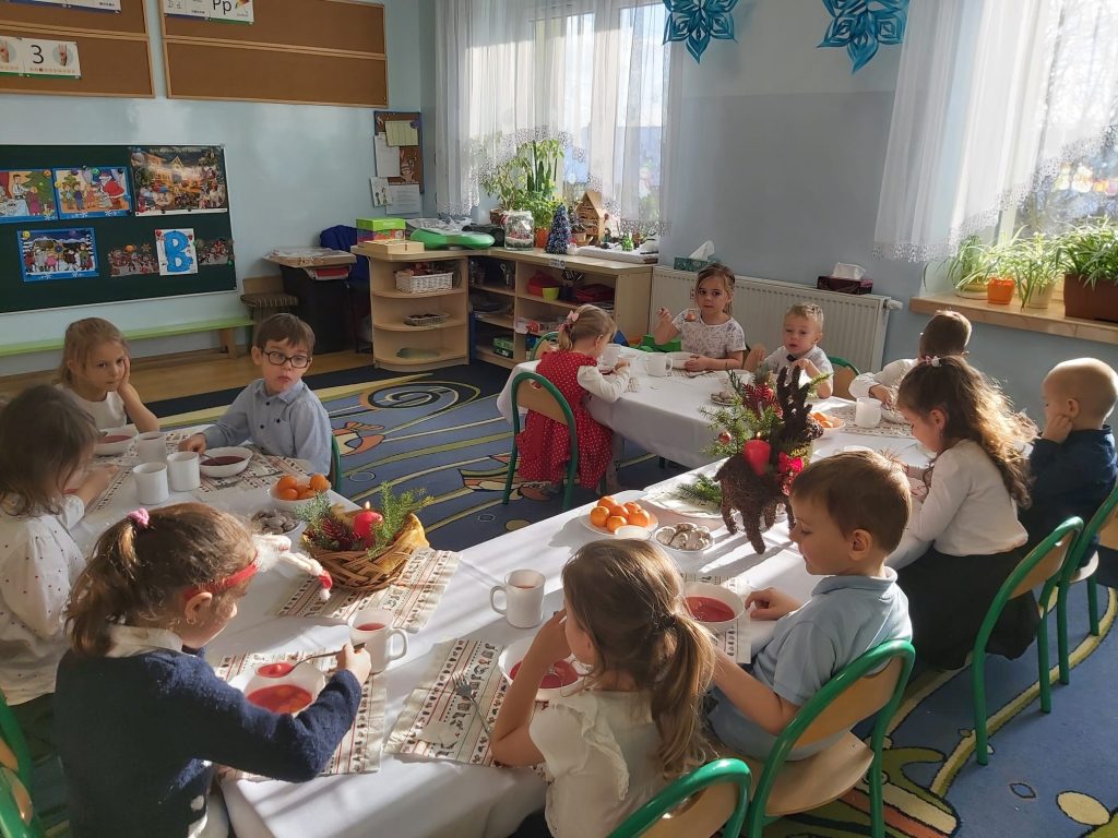 Dzieci podczas spożywania świątecznego posiłku w sali.