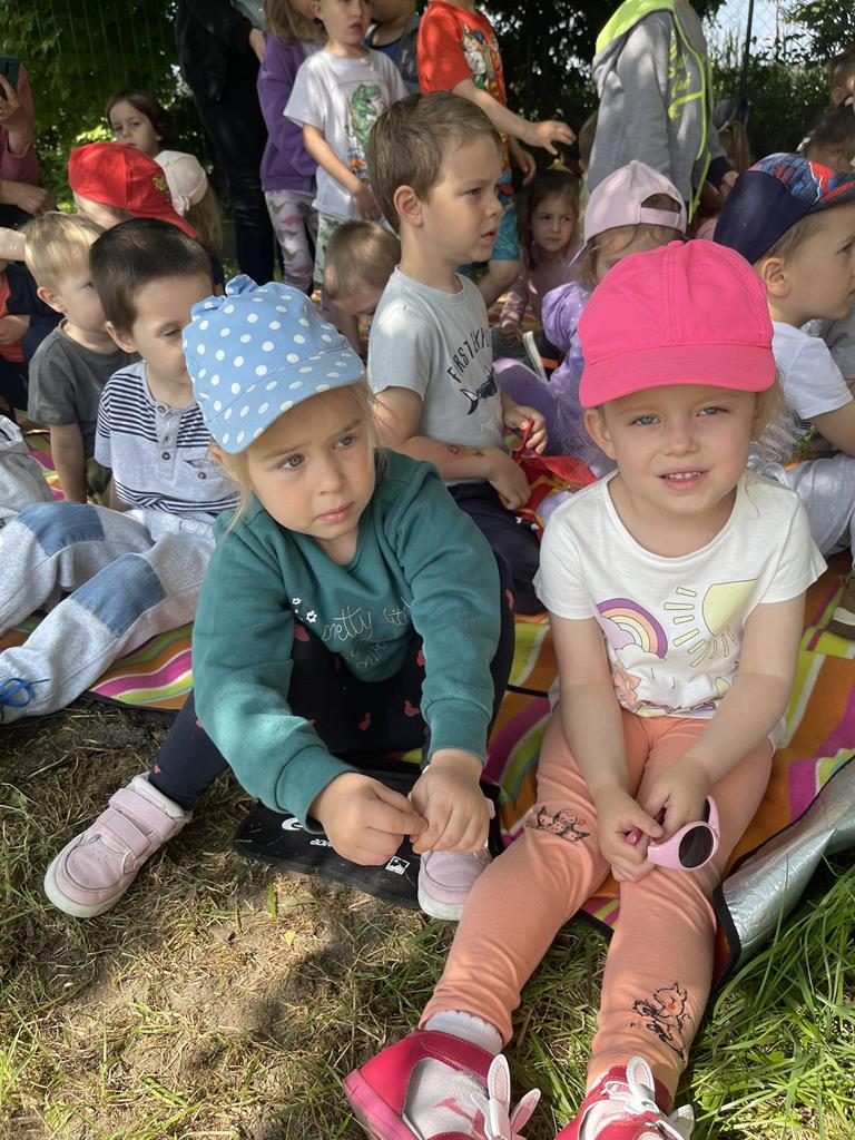 Dziewczynki słuchają wierszy czytanych przez zaproszonych gości.