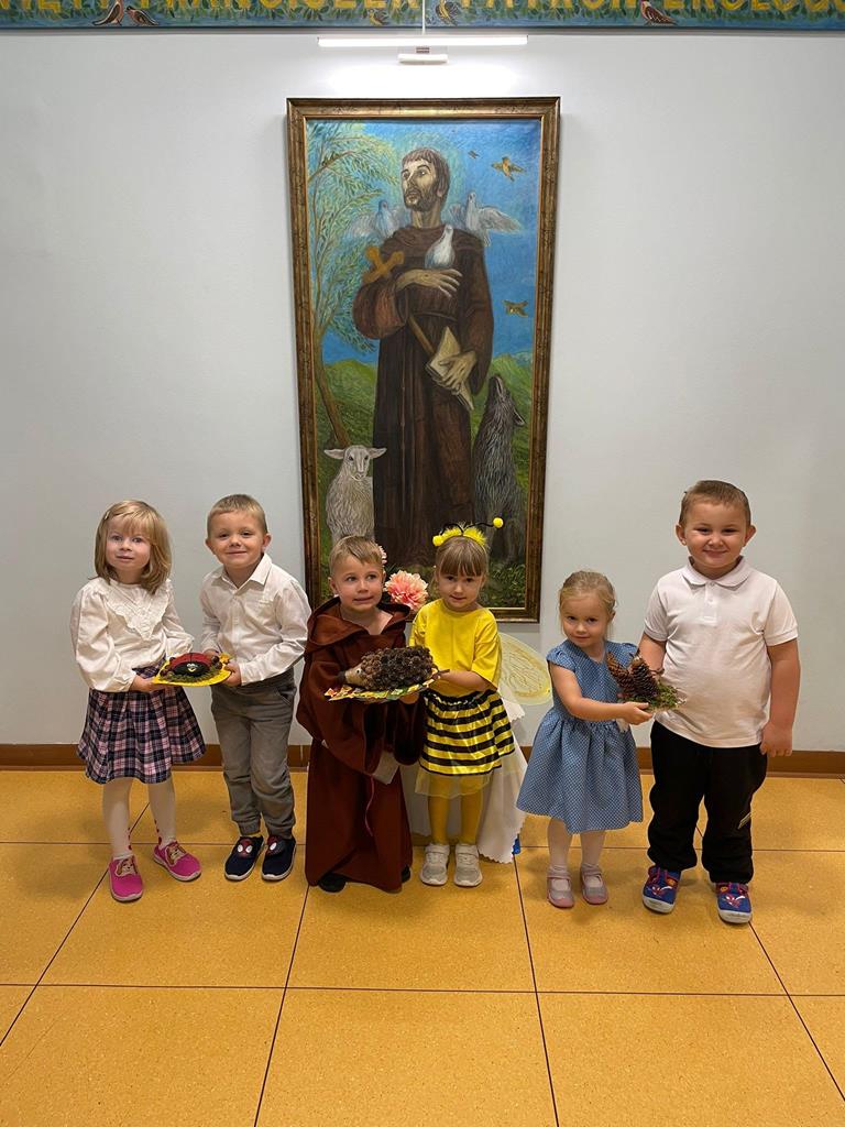 Reprezentanci każdej z grup z darami pod obrazem św. Franciszka.