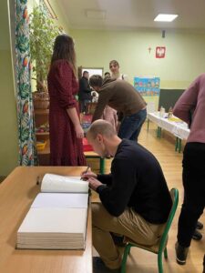 Pan wpisuje się do pamiątkowej kroniki.
