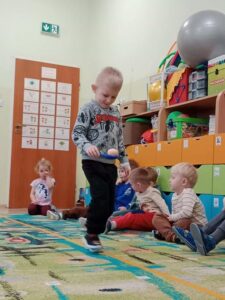 Chłopiec z drewnianą łyżką na której umieszczone jest jajko pokonuje tor przeszkód.