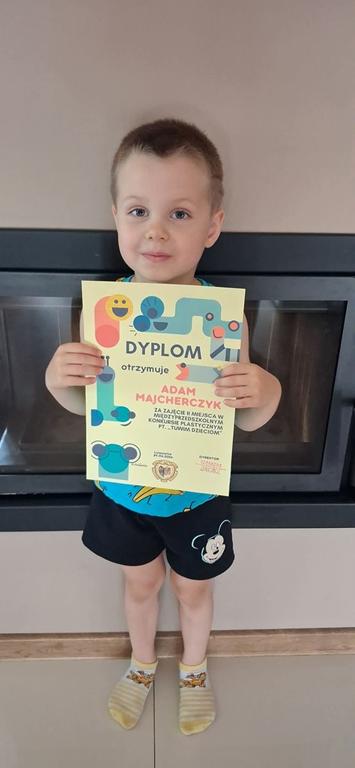 Nagrodzony chłopiec z dyplomem.